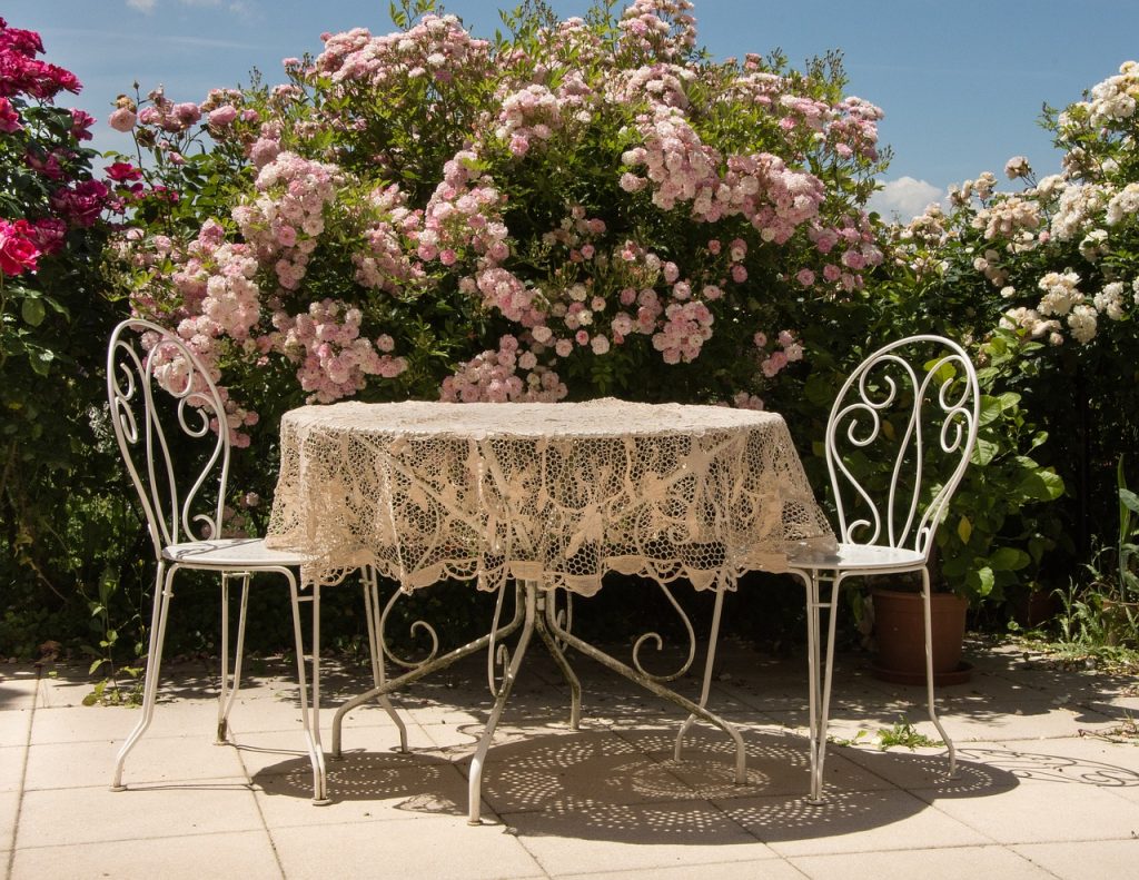 Terrasse Tisch Stühle Sitzen Blumen Hecke Garten